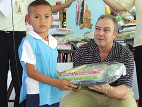Thai Garden Resort General Manager Rene Pisters presents a gift package filled with much needed supplies to this grateful youngster. 