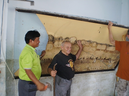 Bernie and the school principal take part in a small ceremony by removing the first damaged wall board to celebrate the beginning of the project. 