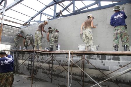 Royal Thai Navy, Malaysian forces and U.S. Navy Seabees with Naval Mobile Construction Battalion 40 apply stucco to a wall of a multipurpose building at the Wat Chalheamlap Temple School as part of Exercise Cobra Gold 2012, in Chonburi, Feb. 1. (Photo by Lance Cpl. Carl Payne)