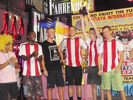 The winning team from the Father Ray Foundation cheerfully raises the trophy.