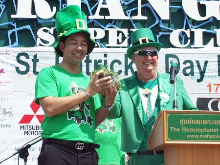 Mayor Itthiphol Kunplome (left) happily accepts a pot of 3-leaf clovers from Derrick Kane, grand marshal of the festival.