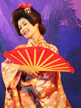 A beautiful geisha performs an enchanting fan dance.