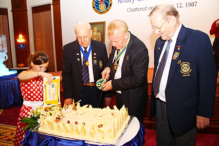 President Gudmund cuts the birthday cake, watched by PP Dennis Stark and PP Max Rommel.