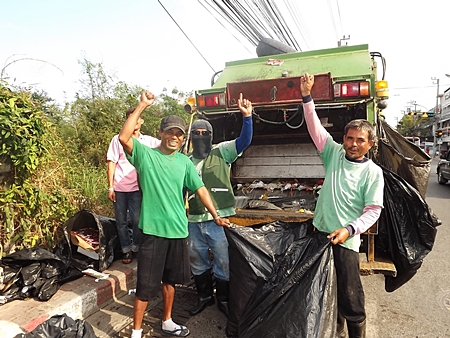 Somjit and fellow garbage collectors at work, picking up refuse to be carted away. 