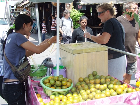 Namthip Mankhong sells a happy customer a cool refreshing orange juice.