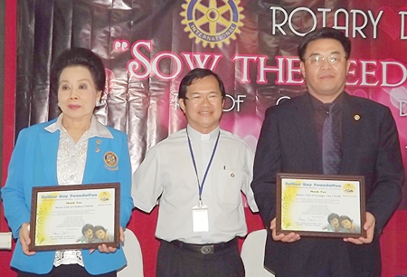 Fr. Michael Picharn Jaiseri (center) presents thank you certificates to Naree Jintakanon (left) and Lee Young Man (right).