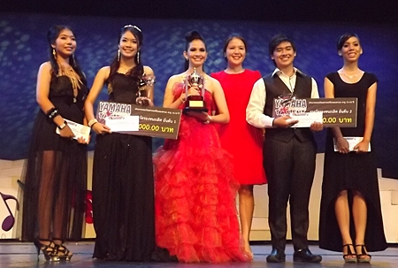 Darin Phanthusak (3rd right), director of Siam Kolakarn School, Pattaya, presents the championship trophy to the winners and runners-up of the Thai / International music category, age 13-18.