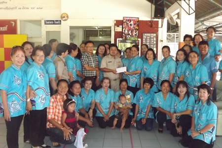 Naowarat Khakhay (standing, center right) presents a donation of 20,000 baht to Athapol Suriya representing the GFPD. 
