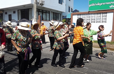 Women dressed in their best flowery blouses march in the Naklua parade.
