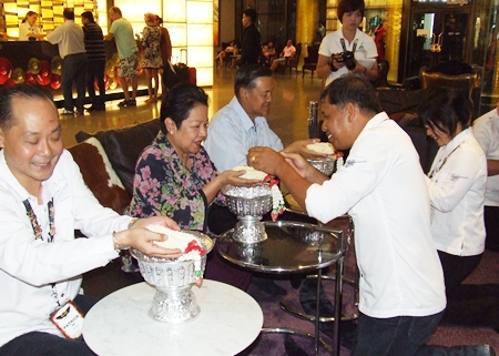 Staff of the Hard Rock Hotel pour scented water and receives blessings from Patrick Ng (left) and Gen Kanit Permsub and Khunying Busyarat.