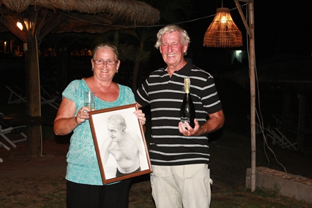 Malcolm celebrates with a bottle of bubbly while wife Norma holds the pencil sketch presented by the Royal Varuna Yacht Club to mark his amazing swim.  