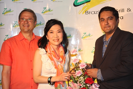 Kamolthep (Prince) Malhotra, right, General Manager of Pattaya Mail Publishing Co., Ltd. offers congratulations and presents a bouquet of flowers to Centara’s Supatra Chirathivat and Andre Brulheart.