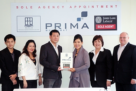 Itthi Chavalittamrong (3rd left), CEO of Petch Pattaya Development Co., Ltd, holds up the contract of appointment of Jones Lang LaSalle as the sole sales agent for Prima Wongamat with Suphin Mechuchep (3 right), Managing Director of Jones Lang LaSalle. 