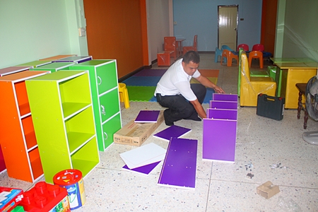 ESC welfare coordinator Samran Naepong assembles cabinets to store all the new items.