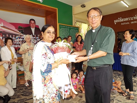 Binota Banerjee presents a donation for the welfare of the orphans to Father Michael.