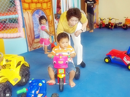 Kyoko Tanaka gives a gentle push to the little boy’s tricycle.