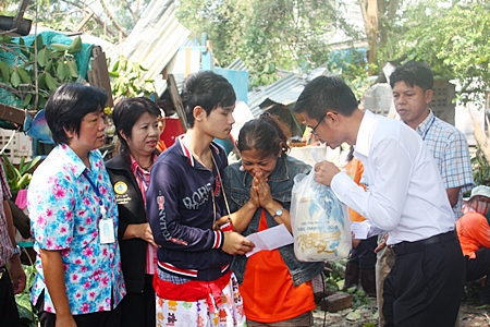 Pattaya Permanent Secretary Pakorn Sukhonthachat presents relief funds and supplies to Siriwan Kuwaentrai, grieving daughter of the deceased. 