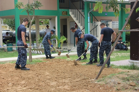 US Navy volunteers till the land so grass can be planted to make the surroundings greener.