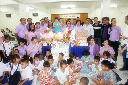 Chonburi Immigration officers, children and orphanage staff gather for a group photo during the presentation. 