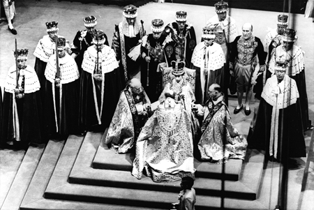 In this June 2, 1953 file photo, Britain’s Queen Elizabeth II, seated on the throne, receives the fealty of the Archbishop of Canterbury, back to camera at center, the Bishop of Durham, left and the Bishop of Bath and Wells, during her coronation in Westminster Abbey, London. (AP Photo, File)