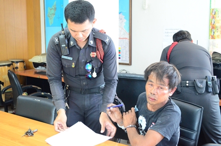 Sumrit Kalasin signs the police report after allegedly trying to rape his neighbor. 