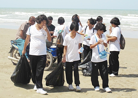 Students from a local school take a water break during their cleanup of Mae Rampung Beach in Rayong. 