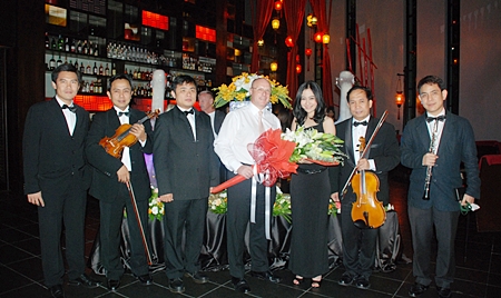 Amari Orchid Pattaya GM David Cumming (4th left) presents flowers to Kaewkan Chuenpennit, thanking her and the other members of the Bangkok Symphony Orchestra.