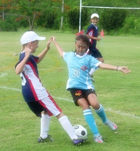 Jade gets stuck in and takes the ball from Garden School, Kuala Lumpur.