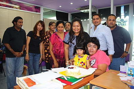 Business came to a stand still for a short spell at the Massic Travel hangar as the Malhotra family gathered around to wish Amita Malhotra (standing 3rd right) a Happy Birthday. (l-r) Vikrom, Hongsiri, Jasmeet, Malvinder, Marlowe, Prince and Ali. Foreground, Vicky is hugging the newest addition, baby Sujitra.