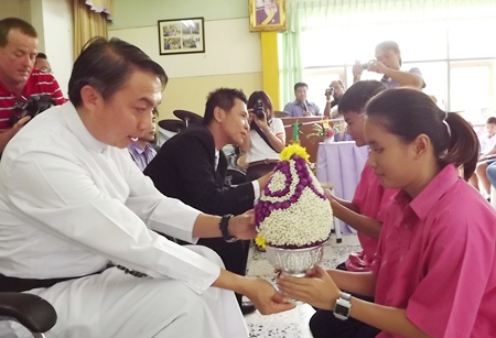 Father Pattarapong Peter Srivorakul, president of the Father Ray Foundation, receives flowers from a blind student.