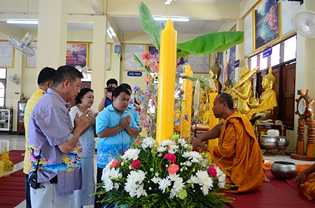 Jeerasak Jitsom, director of Pattaya School #5, representing the teaching committee, presents Lent candles to Wat Nong Or.