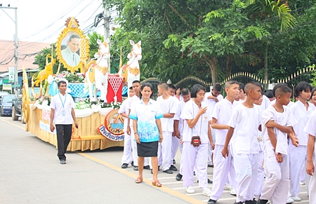 Teachers and students of Wat Suthawat School march in the candle parade to present it to the abbot of Wat Suthawat.