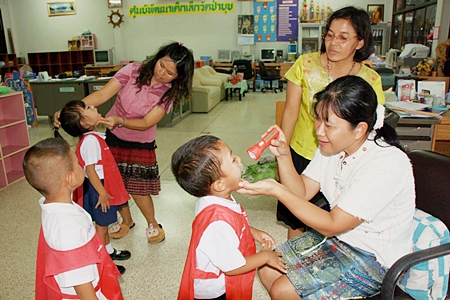 Administrators check young children for signs of hand, foot and mouth disease at the Ya Pa Yub Child Development Center in Khet Udomsak.  The center closed when 93 cases were discovered there.  Rayong thus far has been hardest hit by the outbreak, with 384 infected and 2 deaths. 
