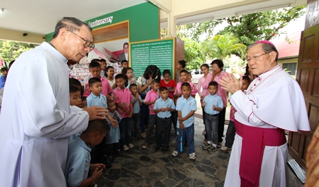 Father Veera Phangrak (left), director of the Pattaya Orphanage, along with children and care givers greet Bishop Emeritus Thienchai Samanjit (right).