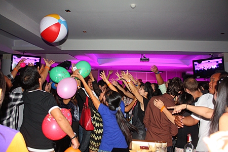 Fans go wild grabbing beach balls with band members’ signatures.