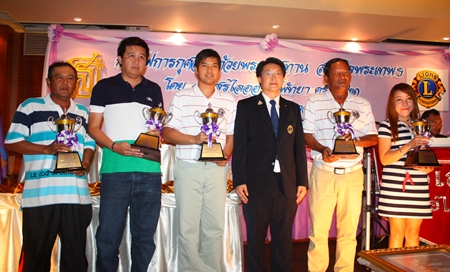 Burin Chanrakkankha, centre, stands with the tournament winners as they parade their trophies.