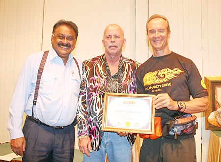 Tournament organizer Mark Gorda, center, receives a certificate of appreciation from Jesters Care For Kids representative Lewis “Woody” Underwood, right, while Peter Malhotra, MD of media sponsors Pattaya Mail Media stands left.