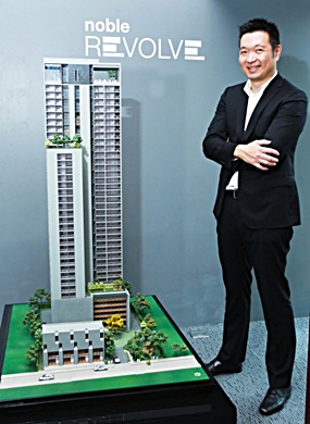 Thongchai Busrapan, Managing Director of Noble Development PCL, stands next to a scale model of the Noble Revolve project. 