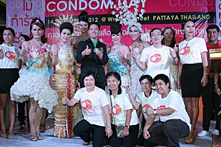 Not your everyday group photo, as event organizers pose with transvestites dressed in costumes made from female condoms.