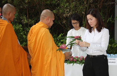 Sudachan Aprirattanapimonchai, Director of Finance & Business Support, leads employees to offer alms to monks at the Havana Bar & Restaurant.