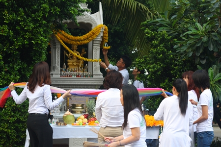 Employees pay homage to the Brahman shrine they use on the hotel grounds.