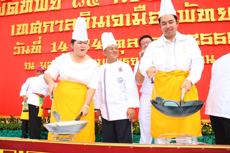 Culture Minister Sukumol Kunplome (left) and Mayor Itthiphol Kunplome (right) stir up their versions of the “Fried Rice in 85 Prosperous Pans”.