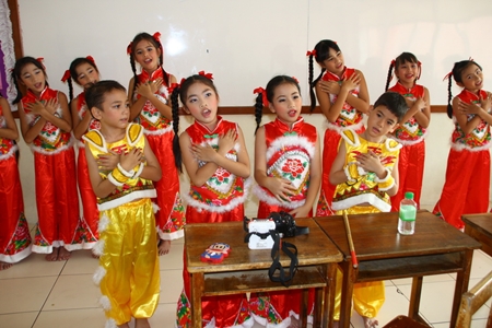 Students dressed in traditional Chinese outfits entertain the honored guests with song and dance. 