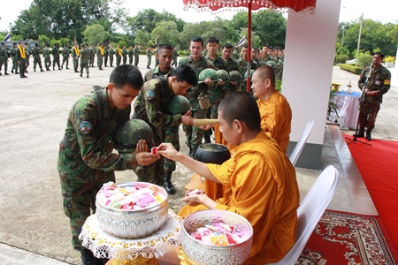 Monks bless the troops and hand out amulets for luck before the troops leave for the south. 