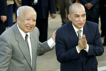 In this Oct. 20, 2004 file photo, Cambodia’s King Norodom Sihanouk, left, introduces his son and successor, King Norodom Sihamoni upon their arrival at Phnom Penh airport, in Cambodia. (AP Photo/Andy Eames, File)