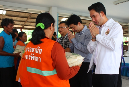 Mayor Itthiphol Kunplome (right) and Chonburi MP Poramet Ngampichet (2nd right) hand out rice to city workers. 