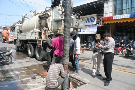 City officials inspect storm drains in Naklua as workers use heavy equipment to clear them of debris that might inhibit water flow during heavy rainfall. 