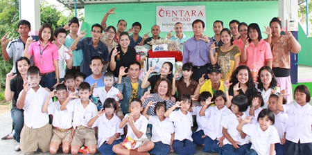 Daranart Nuchaikaew (standing, 7th left), Director of Human Resources at Centara Grand Mirage Beach Resort Pattaya led a group of hotel staff to Baan Huai Khai Nao School where they donated amenities to the school children.  They were welcomed by Thaiphusa Suwanpan (4th right), the school’s director and the happy school children.