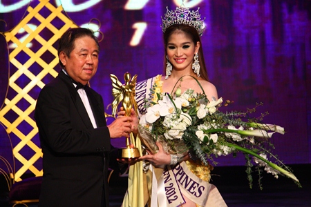 Senator Sutham Phanthusak, MD of the Tiffany Show Pattaya, presents the championship trophy to Kevin Balot, Miss International Queen 2012.