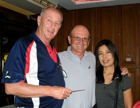 Colin Davis (left) presents a prize to Sunday A Flight winner John Stewart (center) and his wife. 